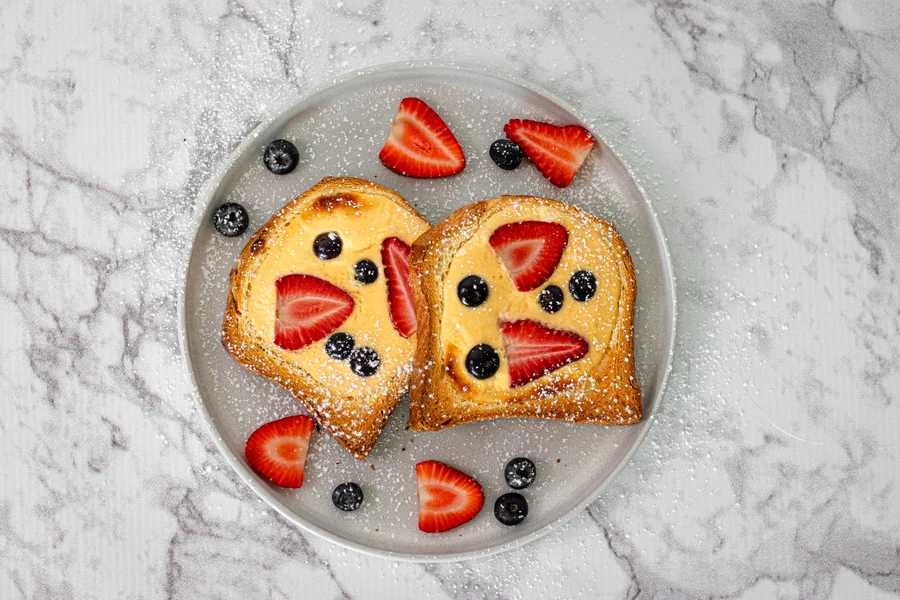 Berry custard toast topped with strawberries and blueberries