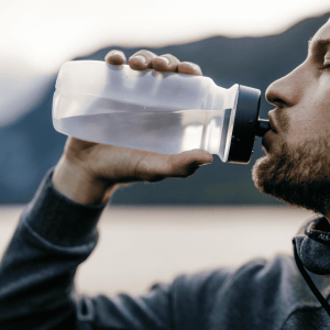 Man takes a drink from his water bottle