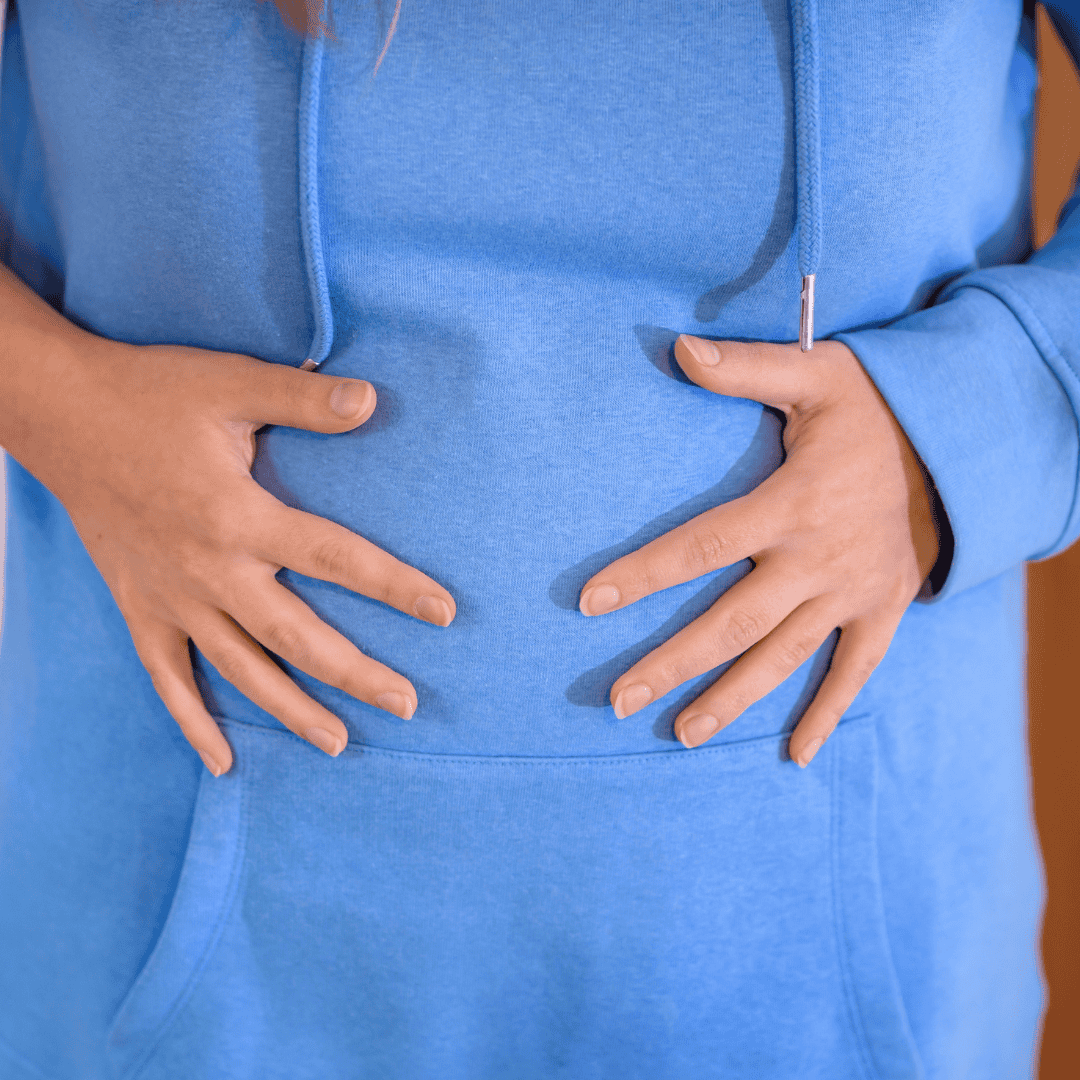 Close-up of a person holding their stomach, symbolizing discomfort from potential food sensitivities. The image highlights the challenges associated with identifying and managing food-related issues.